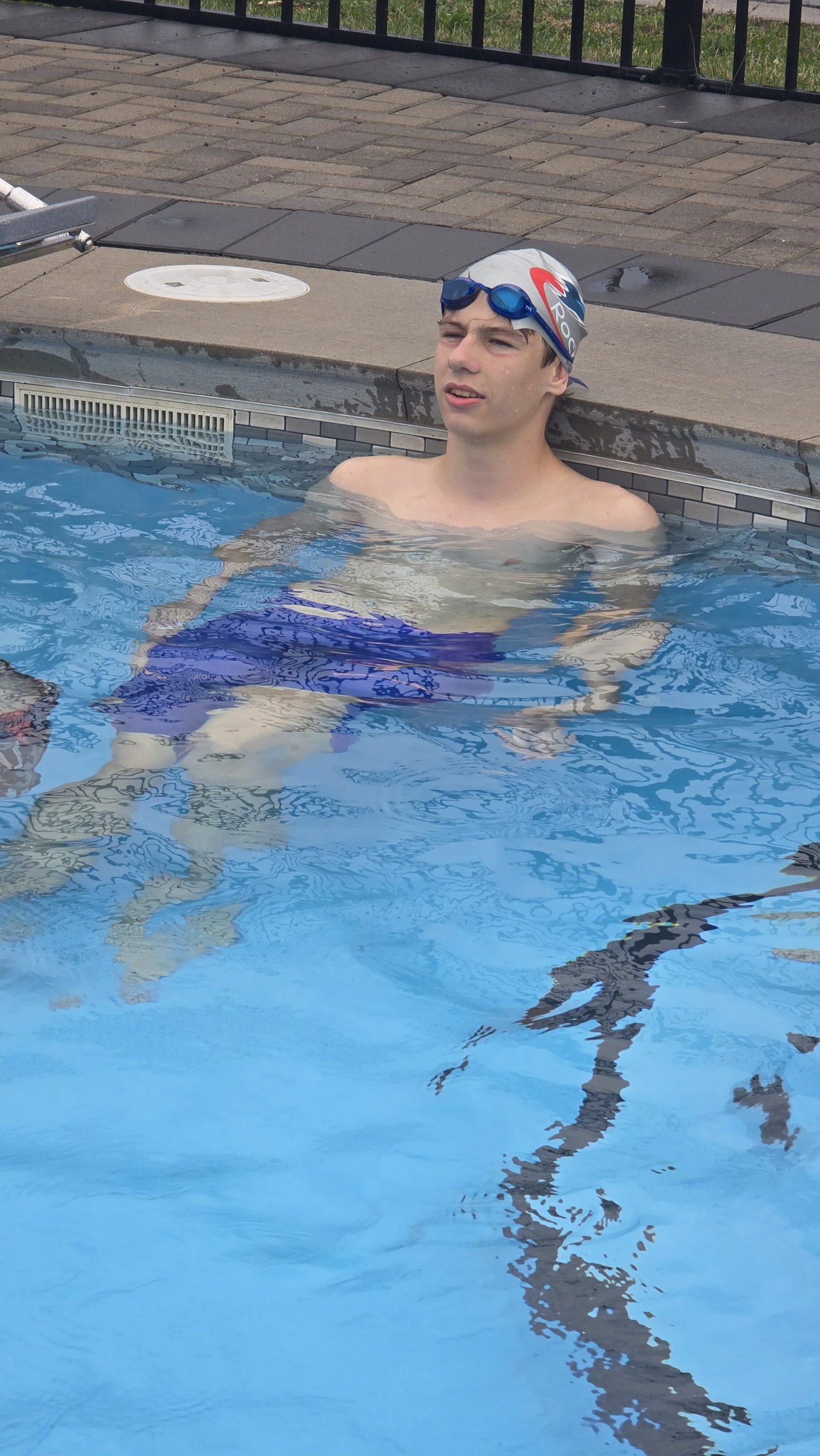 Swimmer wearing a RocketSwim cap in the outdoor pool at summer camp in 2026